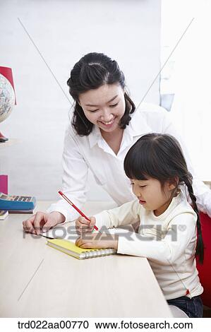 a kid studying at table with a teacher View Large Photo Image Stock Image - a kid studying at table with a teacher. Fotosearch