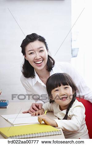a kid studying at table with a teacher View Large Photo Image Stock Photo - a kid studying at table with a teacher. Fotosearch