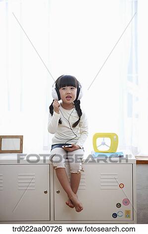 a kid with headphone sitting on table View Large Photo Image Stock Photograph - a kid with headphone sitting on table. Fotosearch