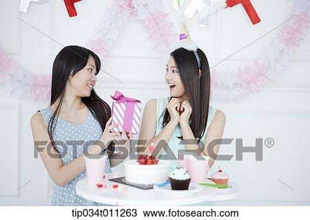 a lady giving a present to her friend View Large Photo Image Stock Image - a lady giving a present to her friend. Fotosearch