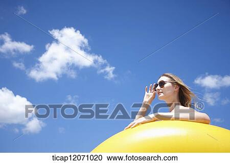 a lady in bikini and beach tube under bright sky View Large Photo Image Stock Image - a lady in bikini and beach tube under bright sky. Fotosearch