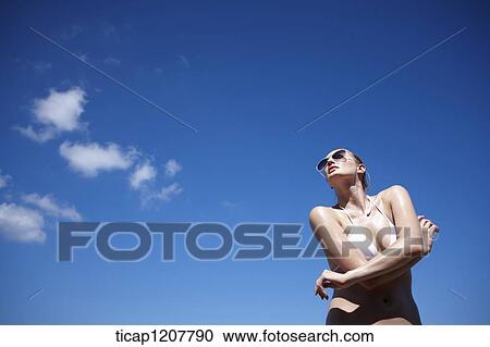 a lady in bikini and sunglasses posing under bright sky View Large Photo Image Stock Image - a lady in bikini and sunglasses posing under bright sky. Fotosearch