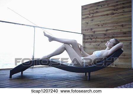 a lady in bikini lying on a beach bed View Large Photo Image Stock Image - a lady in bikini lying on a beach bed. Fotosearch