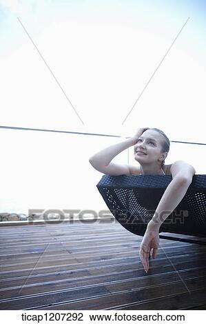 Stock Image - a lady in bikini lying on a beach bed. Fotosearch