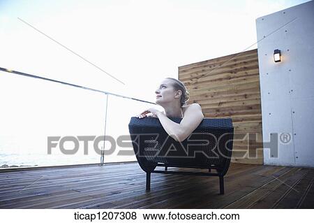 Stock Photo - a lady in bikini lying on a beach bed. Fotosearch