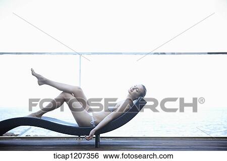 a lady in bikini lying on a beach bed View Large Photo Image Stock Photograph - a lady in bikini lying on a beach bed. Fotosearch
