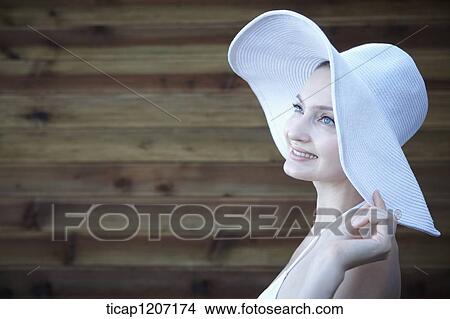 Picture - a lady in bikini wearing beach hat. Fotosearch