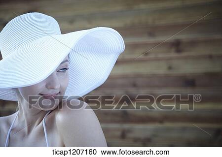 Stock Image - a lady in bikini wearing beach hat. Fotosearch
