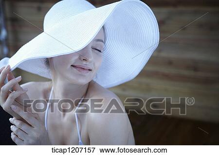Stock Photo - a lady in bikini wearing beach hat. Fotosearch