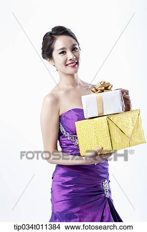 Picture - a lady in fancy purple dress holding a pile of gifts. Fotosearch