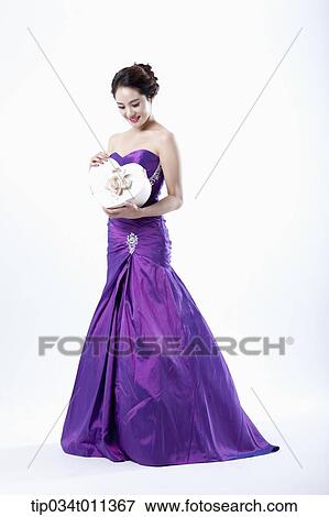 Stock Photo - a lady in fancy purple dress holding a heart shaped box. Fotosearch