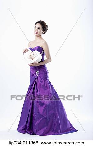 Stock Photo - a lady in fancy purple dress holding a heart shaped box. Fotosearch