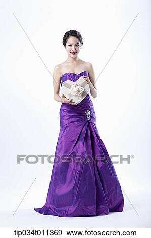 Stock Photo - a lady in fancy purple dress holding a heart shaped box. Fotosearch