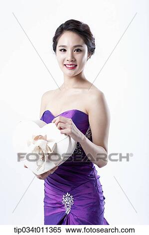 a lady in fancy purple dress holding a heart shaped box View Large Photo Image Stock Photography - a lady in fancy purple dress holding a heart shaped box. Fotosearch
