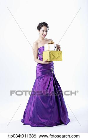 Stock Photography - a lady in fancy purple dress holding a pile of gifts. Fotosearch