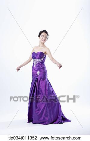 Stock Image - a lady in fancy purple dress posing gracefully. Fotosearch