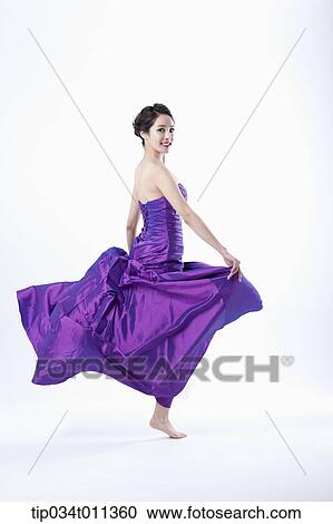 a lady in fancy purple dress posing while jumping View Large Photo Image Stock Image - a lady in fancy purple dress posing while jumping. Fotosearch