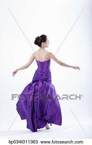 Stock Image - a lady in fancy purple dress posing gracefully. Fotosearch