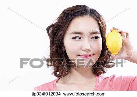 a lady in pink shirt posing with a lemon View Large Photo Image Picture - a lady in pink shirt posing with a lemon. Fotosearch