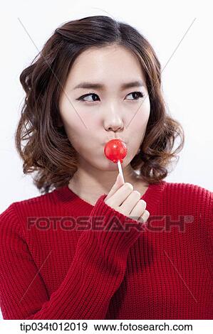 Stock Photo - a lady in red sweater having a lollipop. Fotosearch