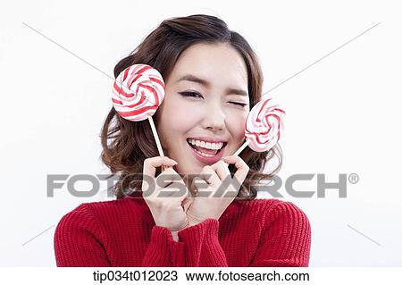 Stock Image - a lady in red sweater posing with lollipops. Fotosearch