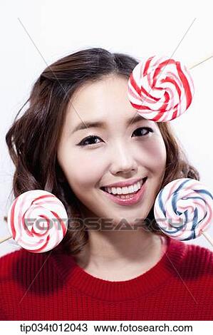 Stock Image - a lady in red sweater posing with lollipops. Fotosearch