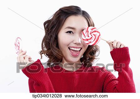 Stock Photo - a lady in red sweater posing with lollipops. Fotosearch