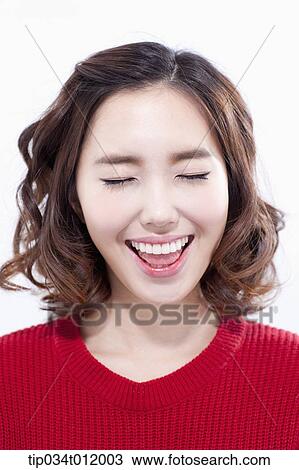 Stock Image - a lady in red sweater smiling with eyes closed. Fotosearch