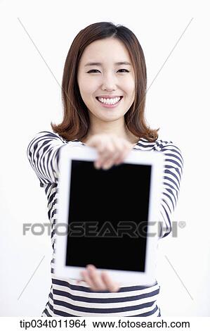 Picture - a lady in striped clothes posing with a tablet PC. Fotosearch