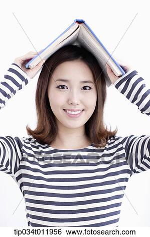 Stock Photograph - a lady in striped clothes posing with a book. Fotosearch