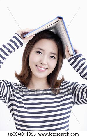 Stock Photography - a lady in striped clothes posing with a book. Fotosearch