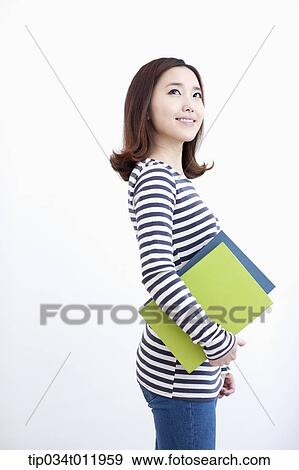Stock Photo - a lady in striped clothes posing with books. Fotosearch