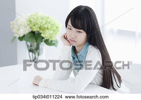 Picture - a lady leaning on a desk. Fotosearch