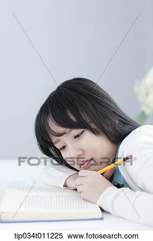 Stock Photography - a lady leaning on a desk reading. Fotosearch