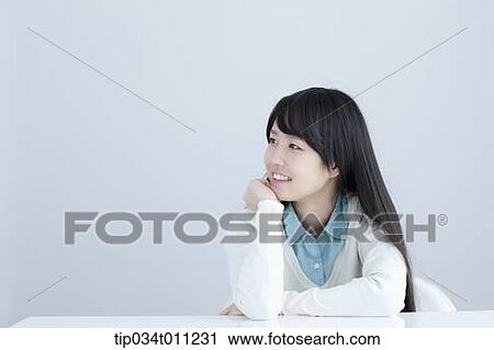 Stock Image - a lady leaning on a desk with arms. Fotosearch