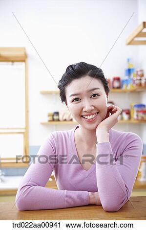 a lady smiling while sitting at table View Large Photo Image Stock Image - a lady smiling while sitting at table. Fotosearch