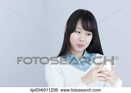 Stock Photo - a lady using a mobile phone. Fotosearch