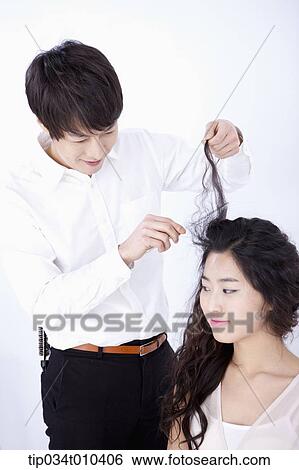 a male hairdresser taking care of woman's hair View Large Photo Image Stock Photograph - a male hairdresser taking care of woman's hair . Fotosearch