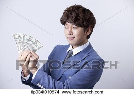 a man looking happy while holding dollars View Large Photo Image Picture - a man looking happy while holding dollars . Fotosearch