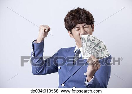 a man looking happy while holding dollars View Large Photo Image Stock Photo - a man looking happy while holding dollars . Fotosearch