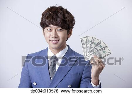 a man looking happy while holding dollars View Large Photo Image Stock Photo - a man looking happy while holding dollars . Fotosearch