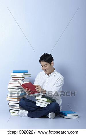 Stock Photo - a man reading books. Fotosearch