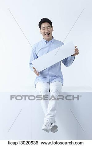 Stock Photograph - a man sitting with a blank paper. Fotosearch