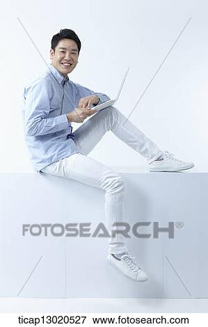 Stock Photo - a man sitting with a laptop. Fotosearch