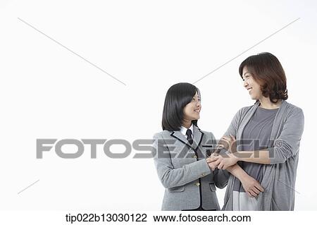 Stock Image - a mother and a daughter in school uniform. Fotosearch