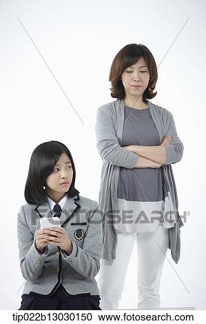 Stock Image - a mother and a daughter with school uniform and a phone. Fotosearch