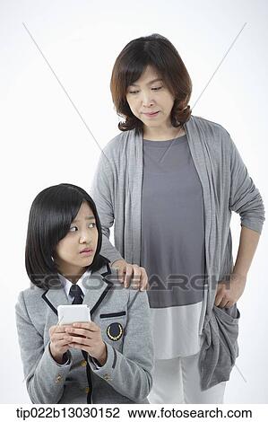 Stock Image - a mother and a daughter with school uniform and a phone. Fotosearch
