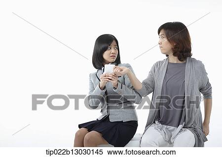 Stock Photography - a mother and a daughter with school uniform and a phone. Fotosearch
