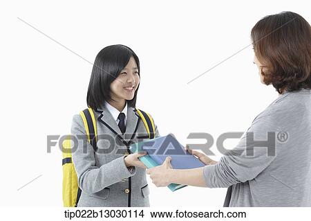 a mother giving school books to daughter in a school uniform View Large Photo Image Picture - a mother giving school books to daughter in a school uniform. Fotosearch