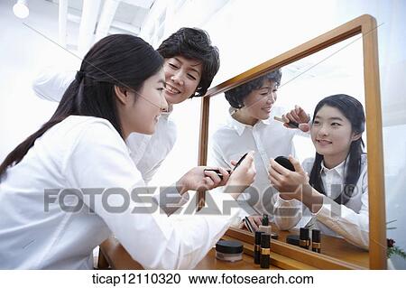 a mother putting on make up for daughter View Large Photo Image Stock Image - a mother putting on make up for daughter. Fotosearch